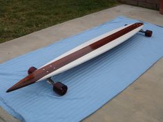 a wooden surfboard sitting on top of a blue blanket