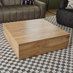 a coffee table sitting on top of a checkered floor in front of a couch