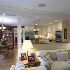 a living room filled with furniture next to a kitchen