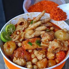 a bowl filled with lots of food on top of a wooden table