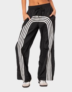 These Nylon Track Pants Offer Both Style And Comfort, Making Them Perfect For A Sporty Yet Fashionable Look. They're Ideal For Any Activity, Ensuring You Feel Comfortable And Confident Throughout Your Entire Day. Track Pants. Contrasting Stripes. Adjustable Tie Waist. Oversized Fit. Nylon Fabric. 100% Polyester. Model Wears Size S. Model Height Is 5'9. Item Care: Wash With Similar Color. | Edikted Wilda Striped Nylon Track Pants Stretch Nylon Wide-leg Parachute Pants, Nylon Sports Trousers, Full-length Nylon Athleisure Pants, Full Length Nylon Athleisure Pants, Sporty Nylon Cargo Pants, Nylon Wide Leg Parachute Pants For Sports, Wide Leg Nylon Parachute Pants For Sports, Athleisure Nylon Pants With Relaxed Fit, Relaxed Fit Nylon Athleisure Pants