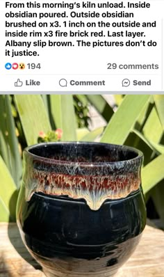 a black vase sitting on top of a wooden table