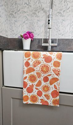 a kitchen sink with an orange towel hanging from the faucet