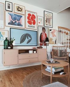 a living room filled with furniture and pictures on the wall