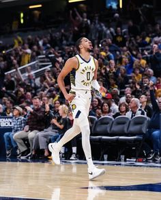 a basketball player is running on the court and fans are in the bleachers