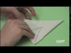 someone is making an origami airplane out of paper