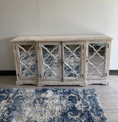 a blue and white rug sitting next to a wooden cabinet on top of a floor