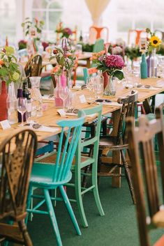 the tables are set with colorful vases and flowers