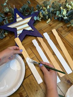 a woman is making wooden stars out of popsicle sticks