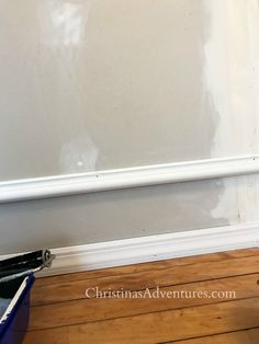 an empty room with white paint on the wall and wood flooring next to it