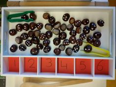 an assortment of chocolate candies and scissors in a tray with numbers on it,