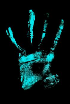 a person's hand is glowing green in the dark