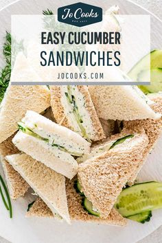 a white plate topped with cucumbers and sandwiches