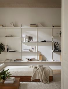 a living room filled with lots of furniture and bookshelves on top of shelves