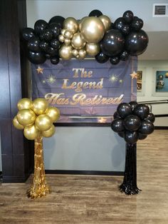 the legend has retired balloon arch with gold and black balloons