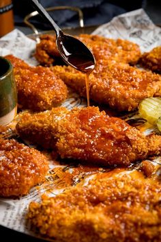 fried chicken is being drizzled with sauce