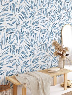 a blue and white wallpaper with leaves on it, next to a wooden bench