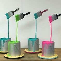 four paintbrushes are being used to decorate cakes