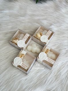 four small boxes with candles in them on a fur surface