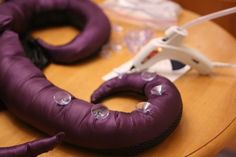 a purple object sitting on top of a wooden table next to scissors and other items