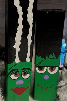 two green and black skis with faces painted on them sitting next to each other