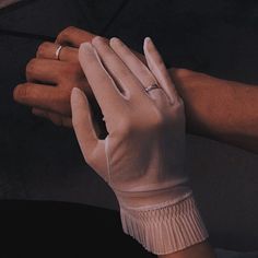 two hands wearing white gloves holding an umbrella