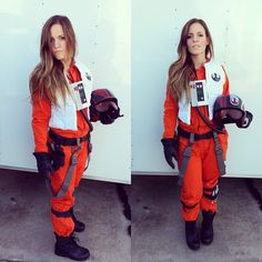 a woman in an orange space suit standing next to a wall