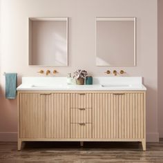 a bathroom with two sinks and mirrors on the wall next to each other in front of a pink wall