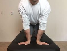 a man standing on top of a black ottoman