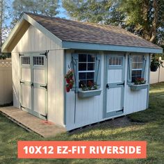 a white shed with windows and flowers in it