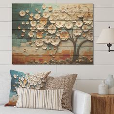 a living room scene with focus on the couch and wall art that has flowers painted on it