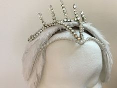 This Swan Lake, Level 3 headpiece, with a clip-on Tiara, was designed by Catherine Zehr. It can be made as Odette, the White Swan, OR as Odile, the Black Swan. The tiara, made separate from the feather headpiece, clips onto the feather headpiece securely. This allows you to use the feather headpiece with or without a tiara. Catherine Zehr, costume designer for New York-based touring company, Ballets with a Twist, is a graduate of the Fashion Institute of Technology in New York, with a degree in Elegant Tall Crown Headpieces For Costume Party, Party Crown Headpieces, Elegant High Crown Headpiece For Costume, Elegant Tall Crown For Party, Elegant Headpiece With Structured Crown For Costume Party, Elegant Structured Crown Headpiece For Costume Party, White Tall Crown Headpiece For Parties, White Rhinestone Party Headpiece, Silver Crown Headpiece For Parties