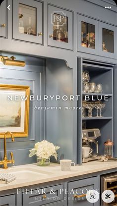 a kitchen with blue cabinets and white flowers in vases on the sink countertop