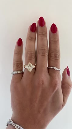 a woman's hand with three different rings on her fingers and one ring in the middle