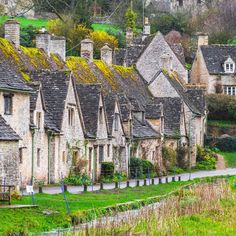 an old village with stone buildings and green grass