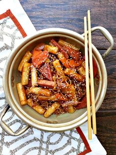 a bowl filled with meat and vegetables next to chopsticks on top of a table