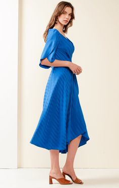 Make an impact in the gorgeous Hanworth House Wrap Dress. A wrap design that hugs your body in all the right places offering flexibility and shape through the waist. Take note of the fluted split sleeve and full skirt for an added dose of drama. We love the easy breezy fit and the vibrant lush cobalt hue! The fabric is soft to the touch and also has a beautiful satin self-stripe that is subtle yet sophisticated. Wear to cocktail events, weddings, luncheons, and also pair with a fascinator for the races!  Self stripe fabric adding subtle sophistication V-neckline to flatter all bust sizes Wrap style, fitted at the torso and you can use the ties to add flexibility and shape through the waist 3/4 fluted wrap petal sleeve for added arm coverage Designed in Australia 53% Rayon, 47% Viscose Cold Bride Top, Split Sleeve, Petal Sleeve, Make An Impact, Travel Dress, Kimono Cardigan, Easy Breezy, Wardrobe Style, Striped Fabrics