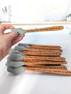 a person holding a wooden spoon in front of a stack of kitchen utensils