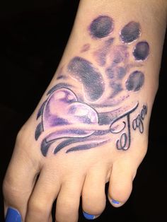 a foot with a tattoo on it that says tatoo and has an image of a dog's paw