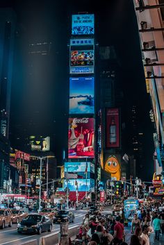 a busy city street filled with lots of traffic and tall buildings lit up at night