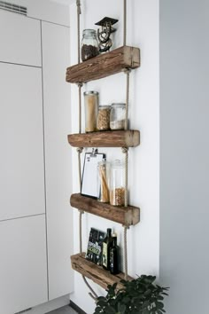 three wooden shelves holding various items on them and hanging from the wall in front of a white door