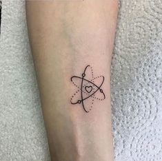 a small black and white tattoo design on the ankle, with an arrow in the center