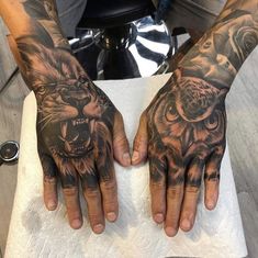 two hands with tiger tattoos on them