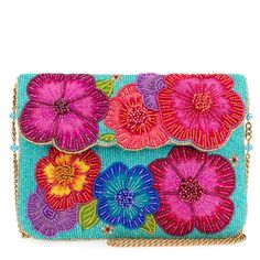 an embroidered clutch bag with flowers on the front and side, hanging from a gold chain