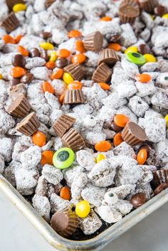 a pan filled with candy and cookies on top of a table