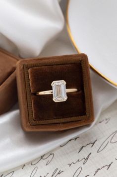 an engagement ring with a baguette cut diamond in it sitting on top of a napkin