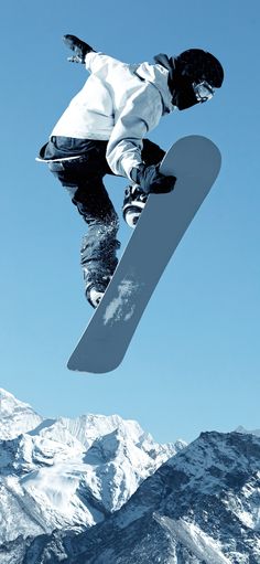 a man flying through the air while riding a snowboard on top of a mountain