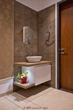 a bathroom with a sink, mirror and plant on the counter in front of it