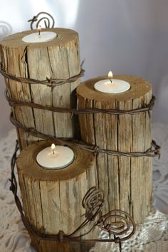 three wooden logs are stacked on top of each other with lit candles in the middle