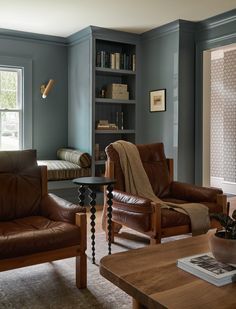 a living room with two leather chairs and a coffee table